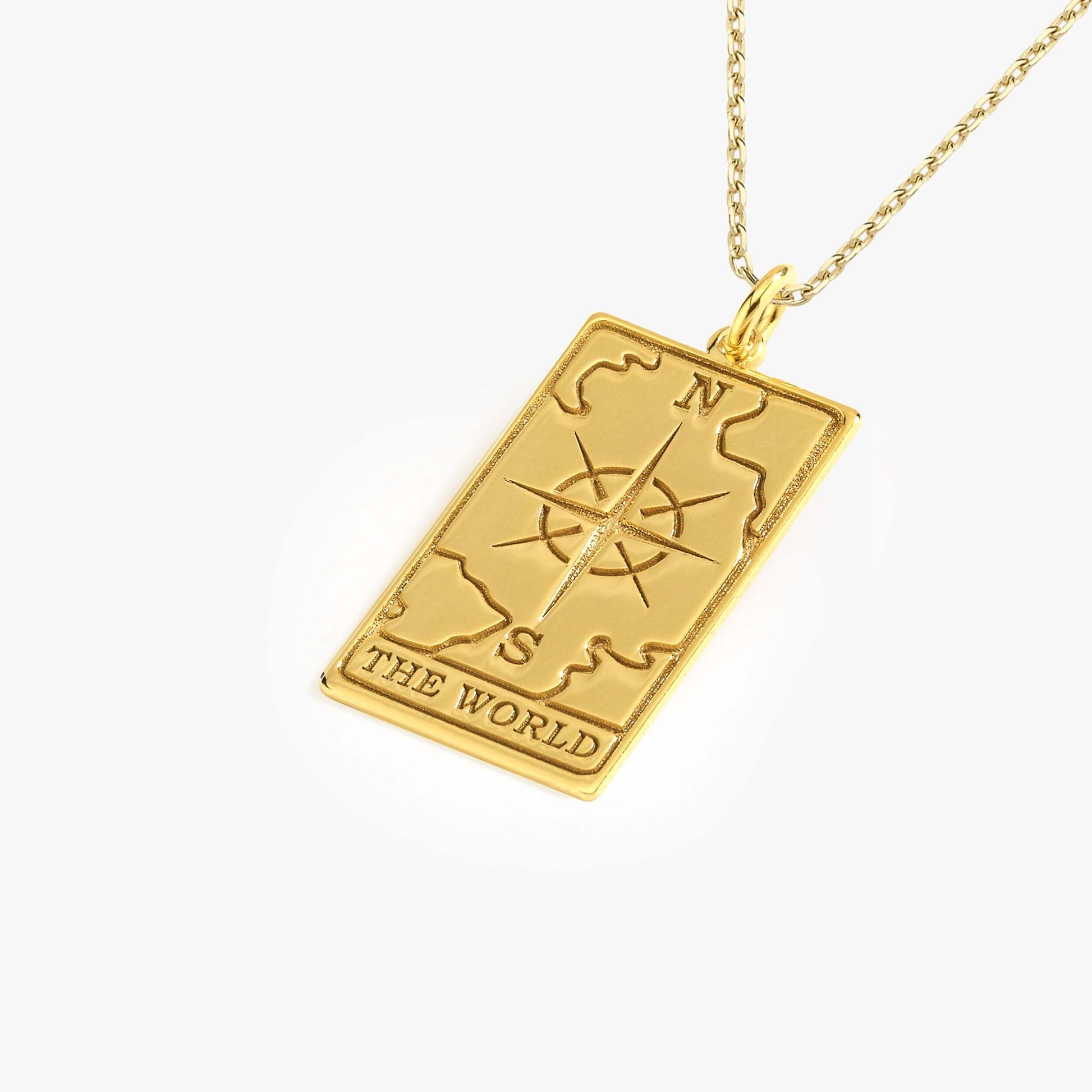 Gold compass pendant necklace with world map design, featuring "The World" engraving, on a delicate chain.