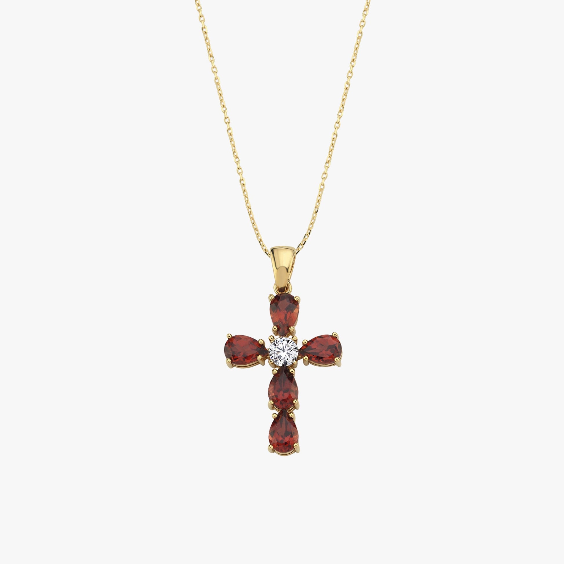 Gold necklace with cross pendant featuring red gemstones and central diamond on a delicate chain.