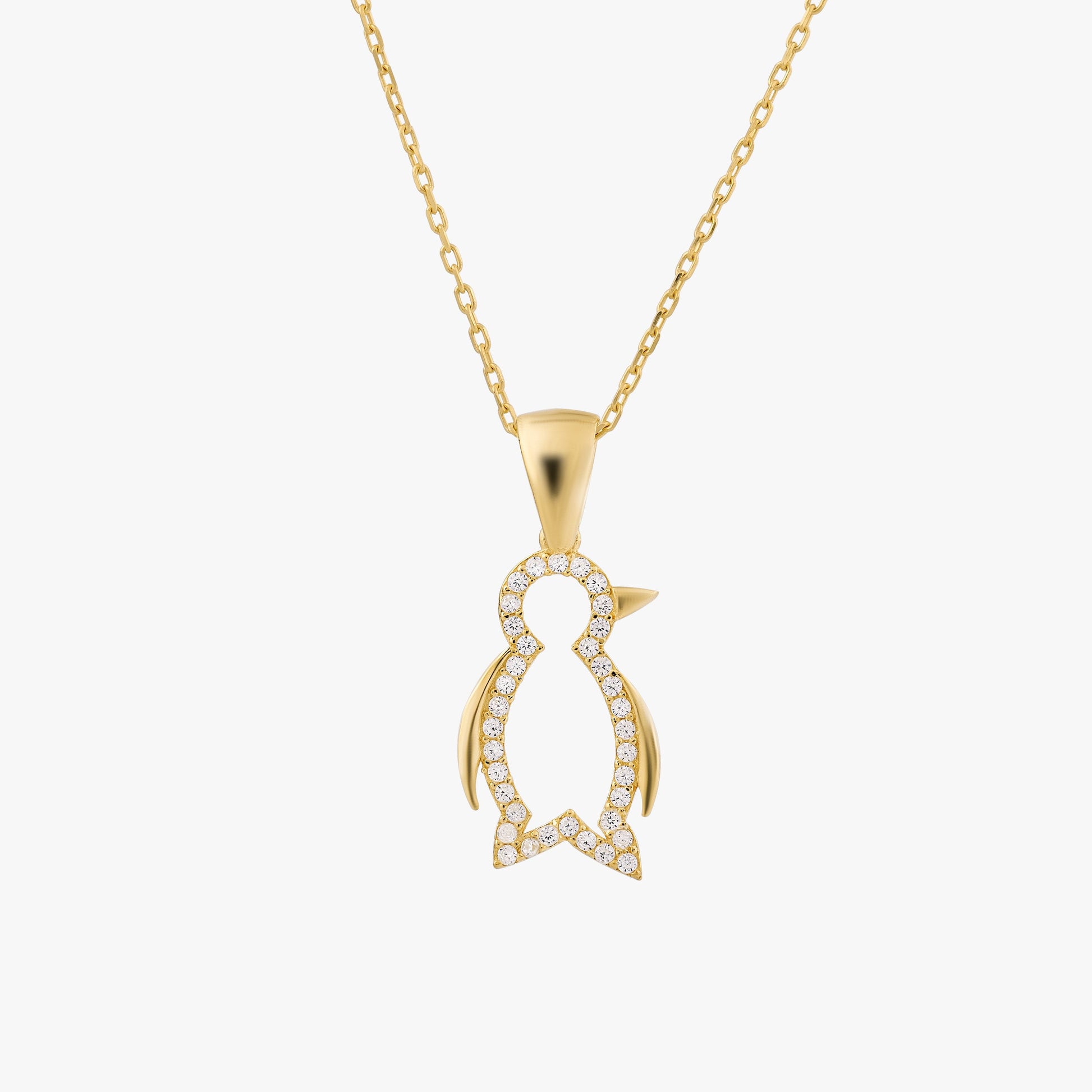 Gold penguin necklace with diamond accents, elegant jewelry piece on a delicate chain, perfect for stylish occasions.