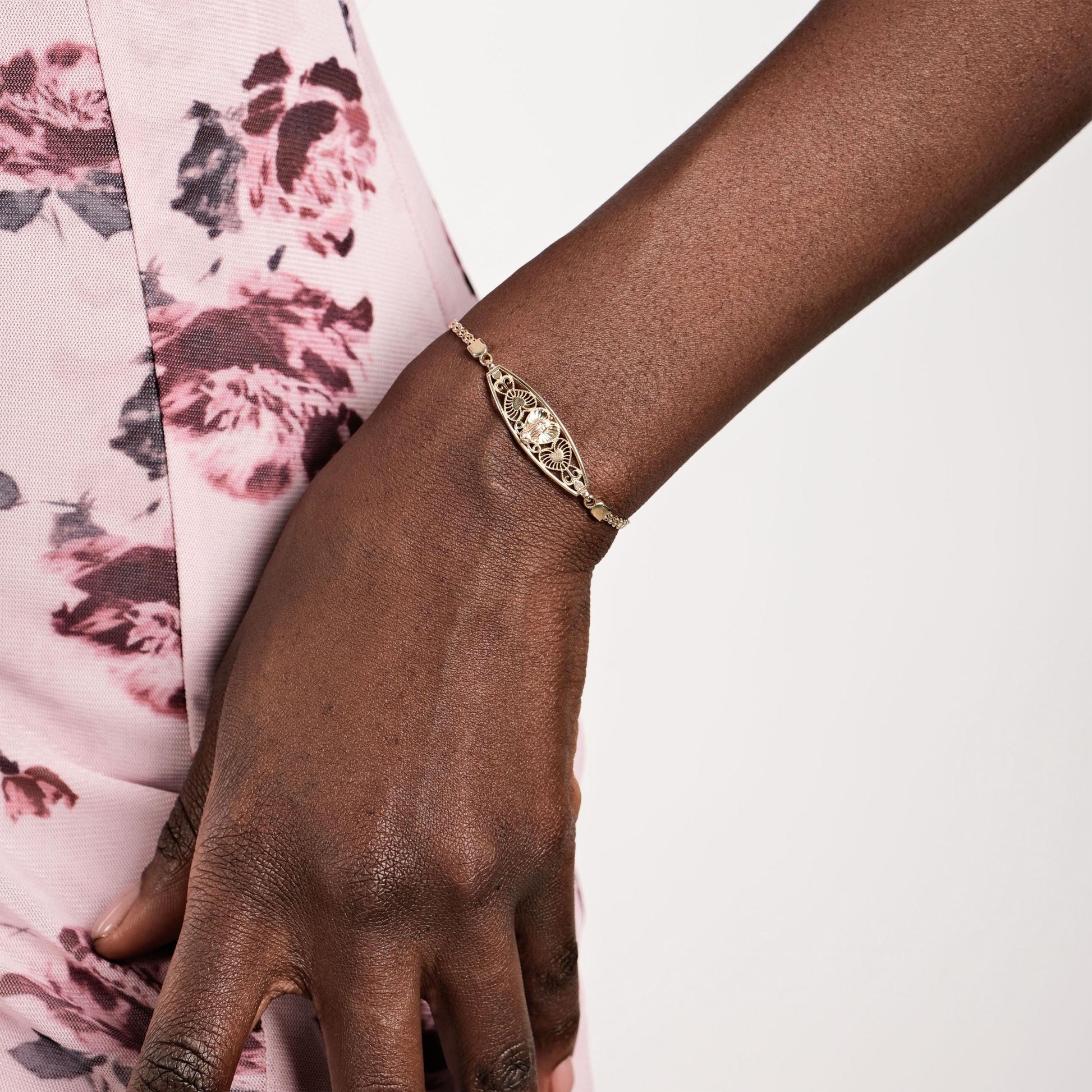The 14K solid gold Virgen de Guadalupe bracelet displayed on a wrist, highlighting its intricate religious design.