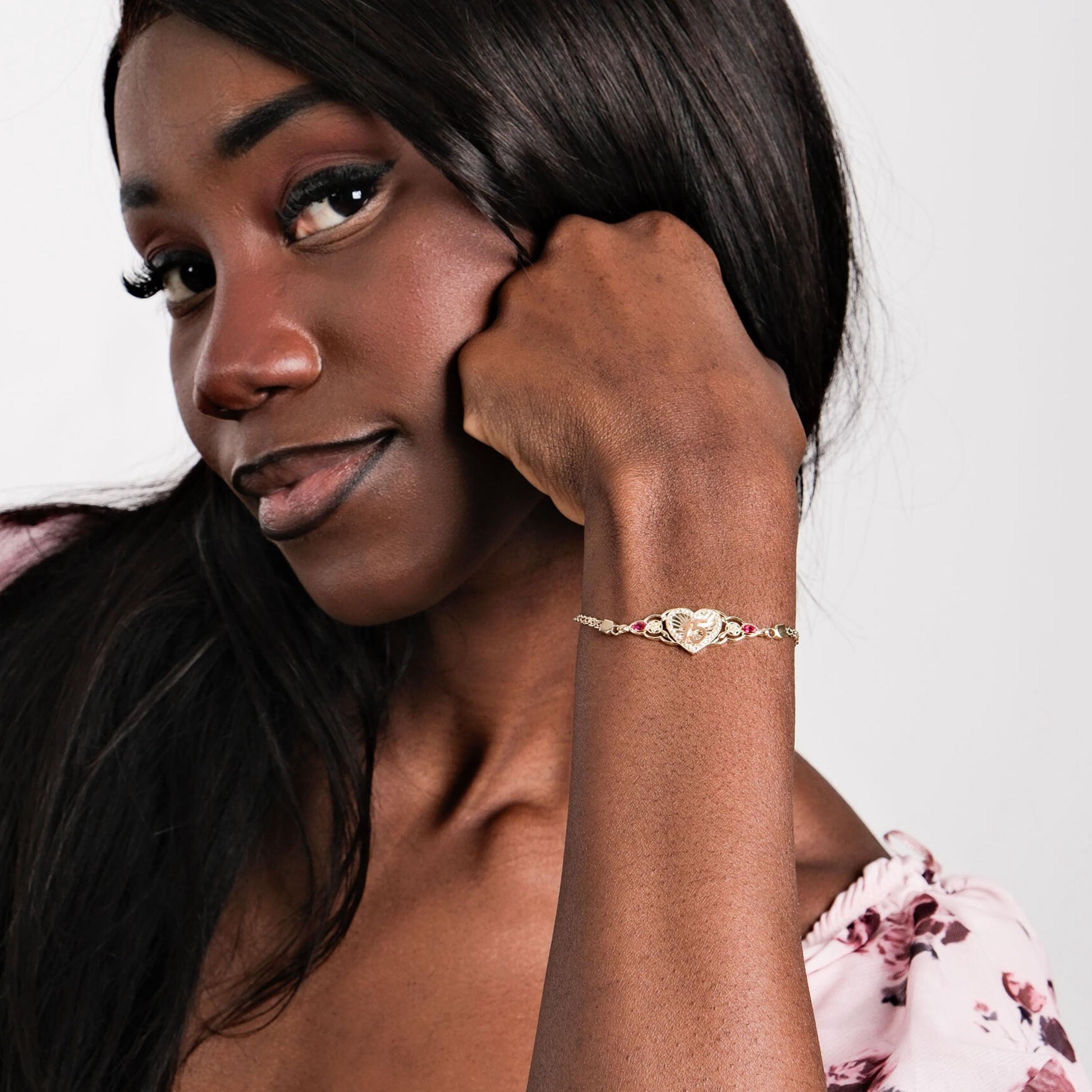 A young woman smiling while elegantly wearing a Quinceañera Gift bracelet, emphasizing its delicate craftsmanship.