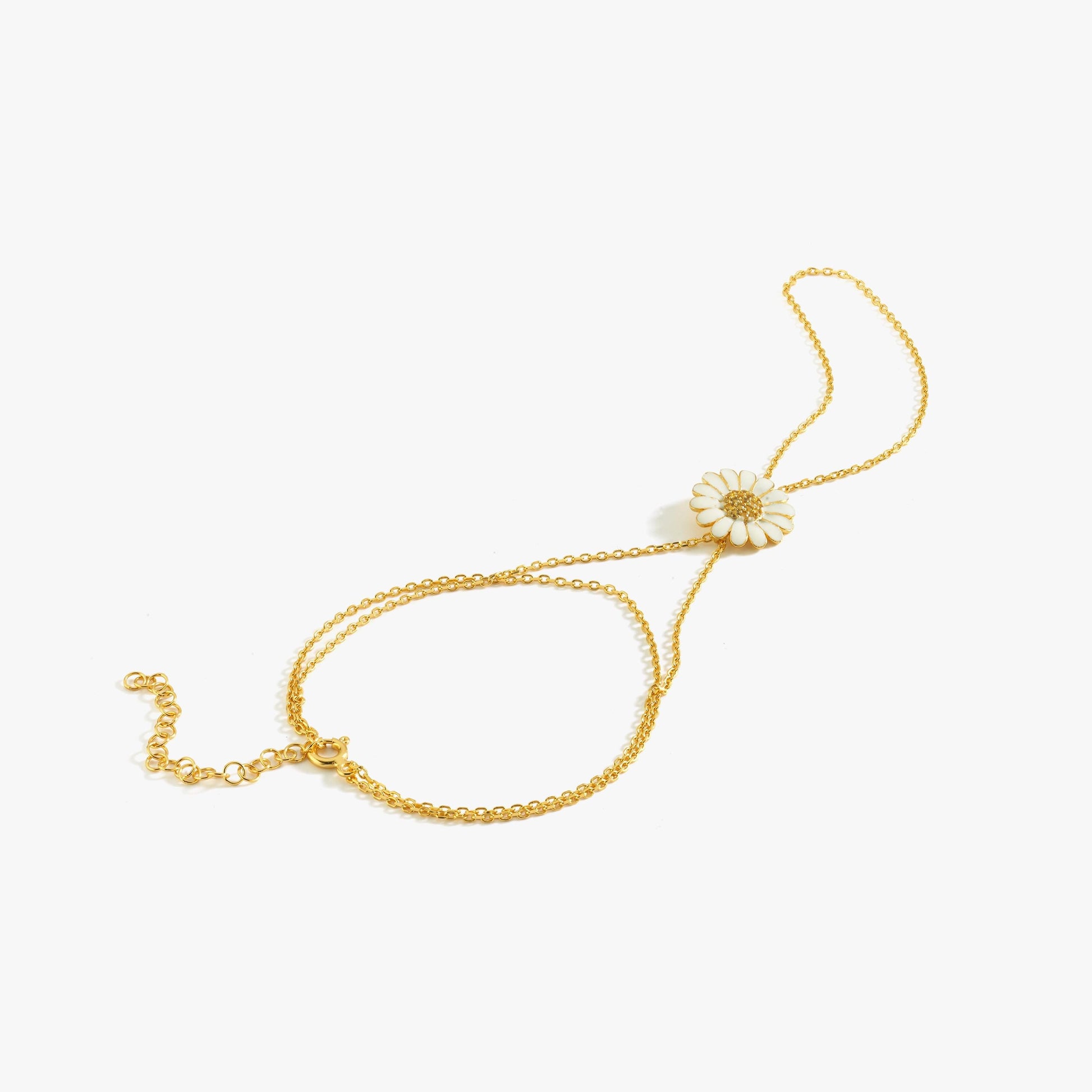 A minimalist shot of a gold daisy bracelet laid flat, showcasing its intricate floral charm and fine chain.