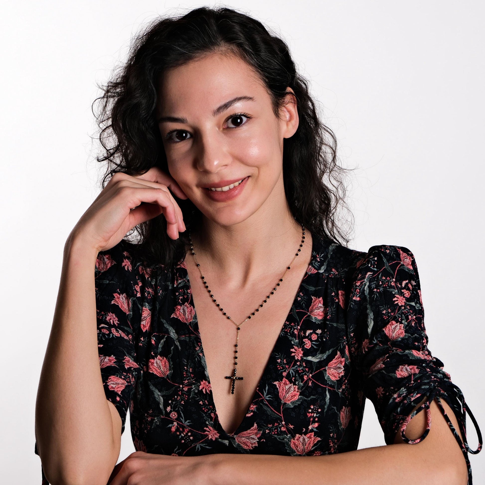 The necklace drapes elegantly around the model’s neck, with the cross pendant resting at the center.