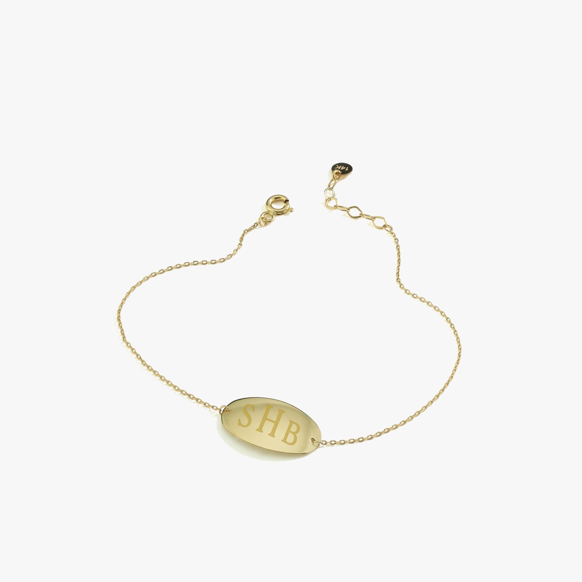 Minimalist 14K solid gold custom bracelet with “SHB” initials engraved on a polished oval charm, displayed on a white background.