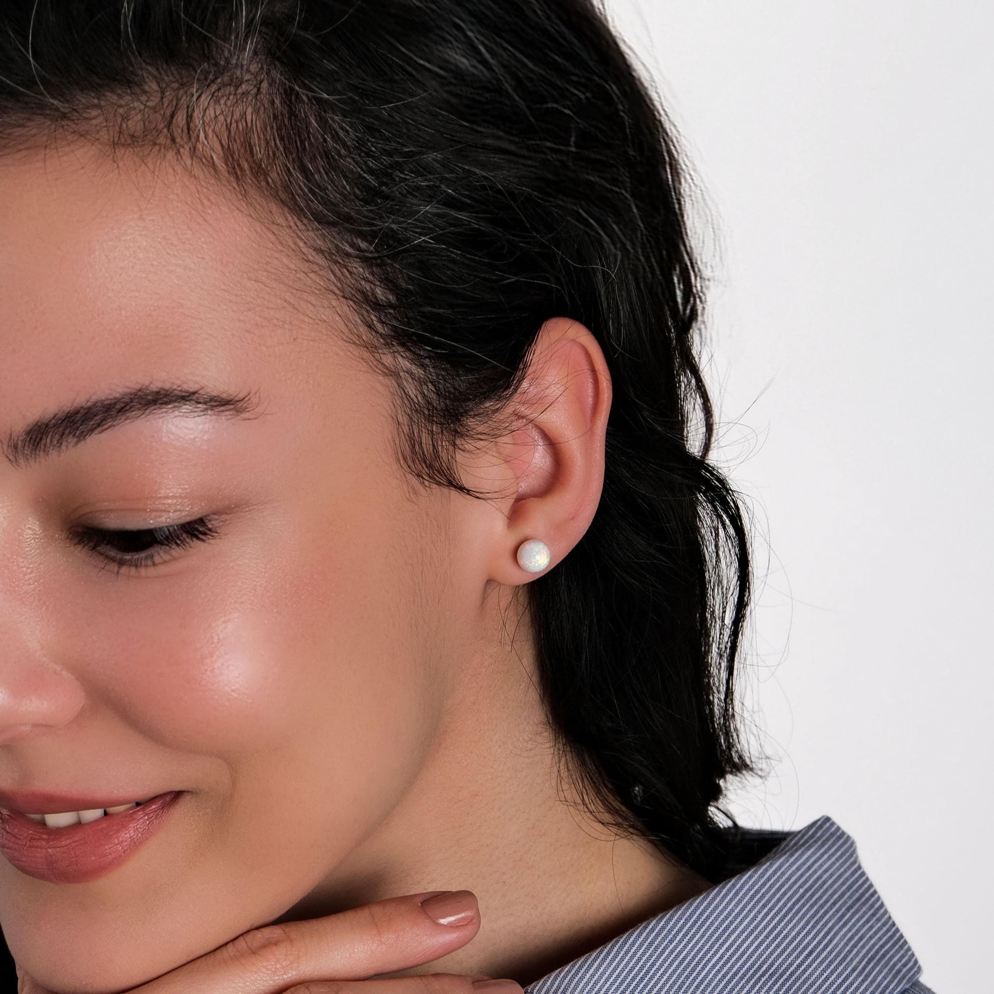 A stylish portrait of a model wearing 14K gold opal earrings, perfectly complementing a chic outfit.