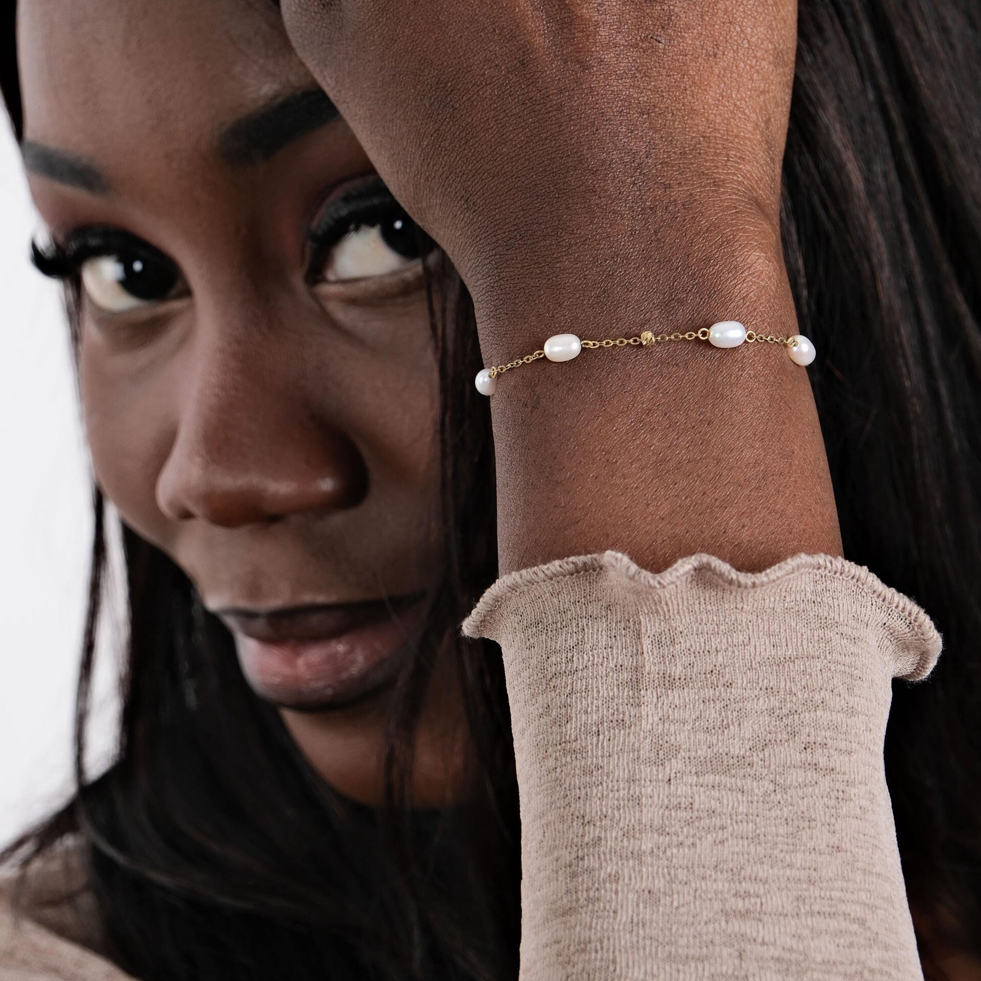 A model wearing the 14K solid gold freshwater pearl bracelet, showcasing its dainty design and classic pearl arrangement.