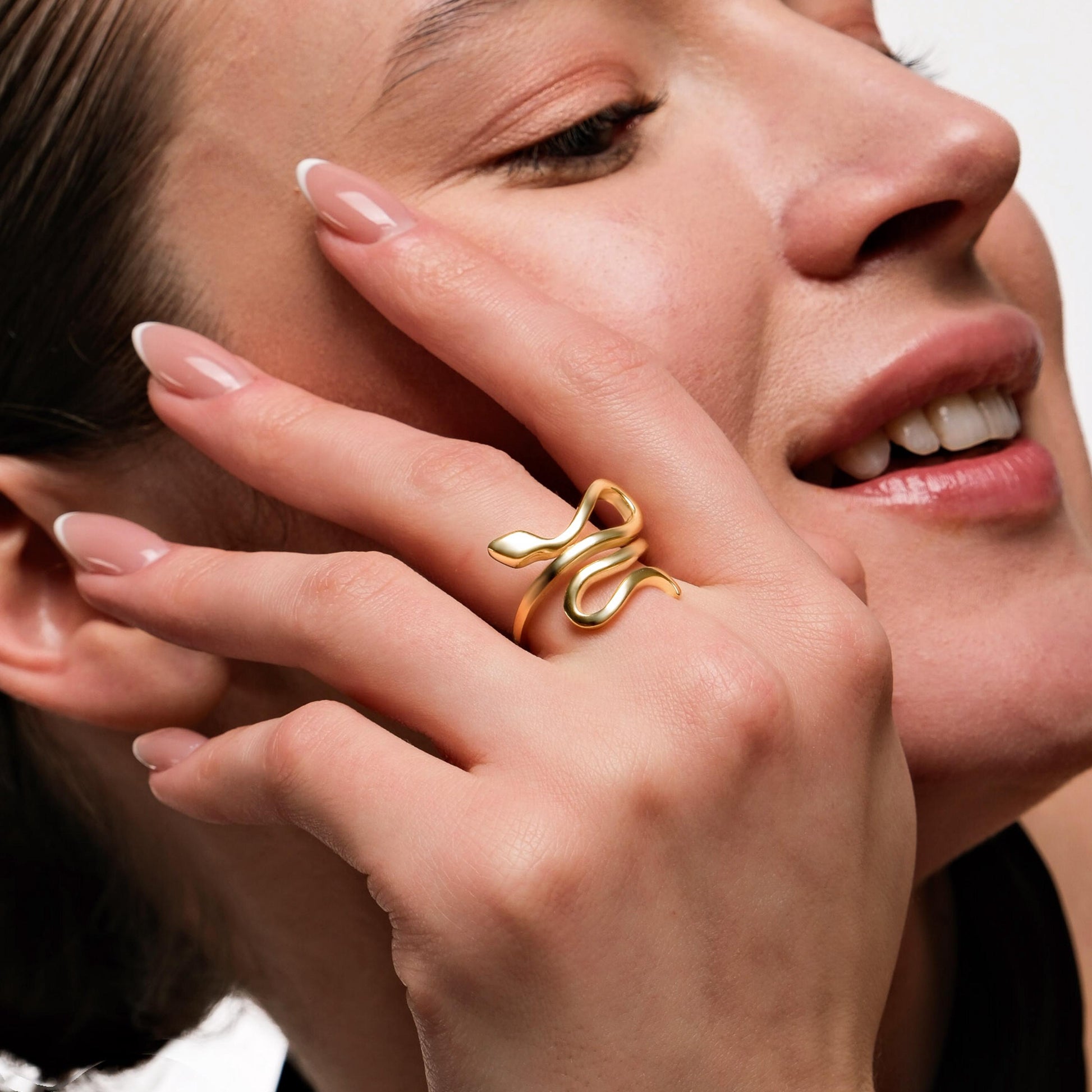 A stylish gold snake ring adding an edgy yet elegant touch to the model’s look.