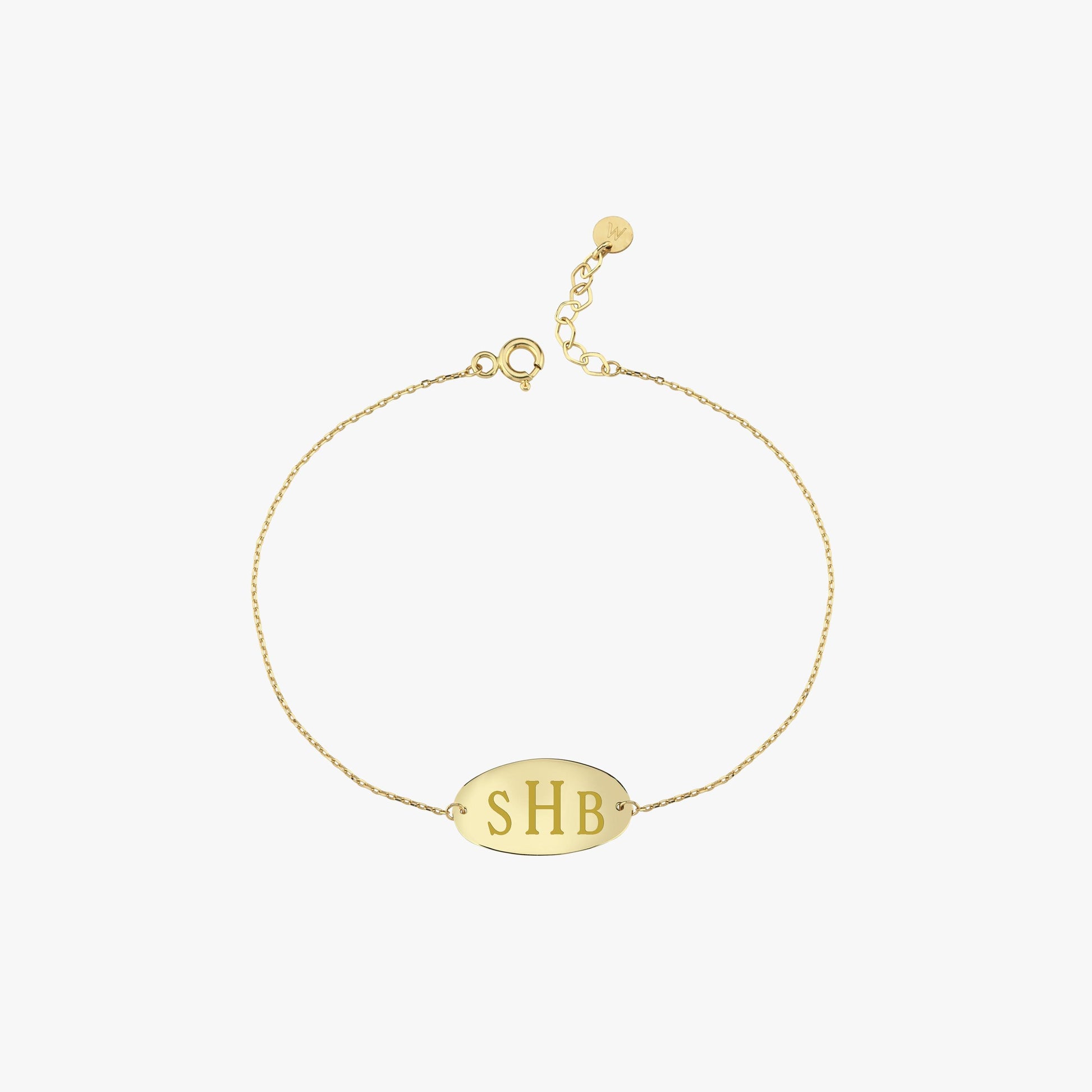 Woman gently touching her neck while showing off a delicate 14K solid gold bracelet engraved with initials “SHB”.