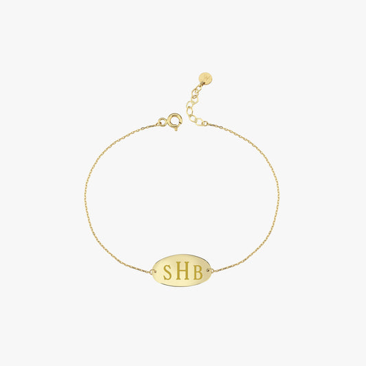Woman gently touching her neck while showing off a delicate 14K solid gold bracelet engraved with initials “SHB”.