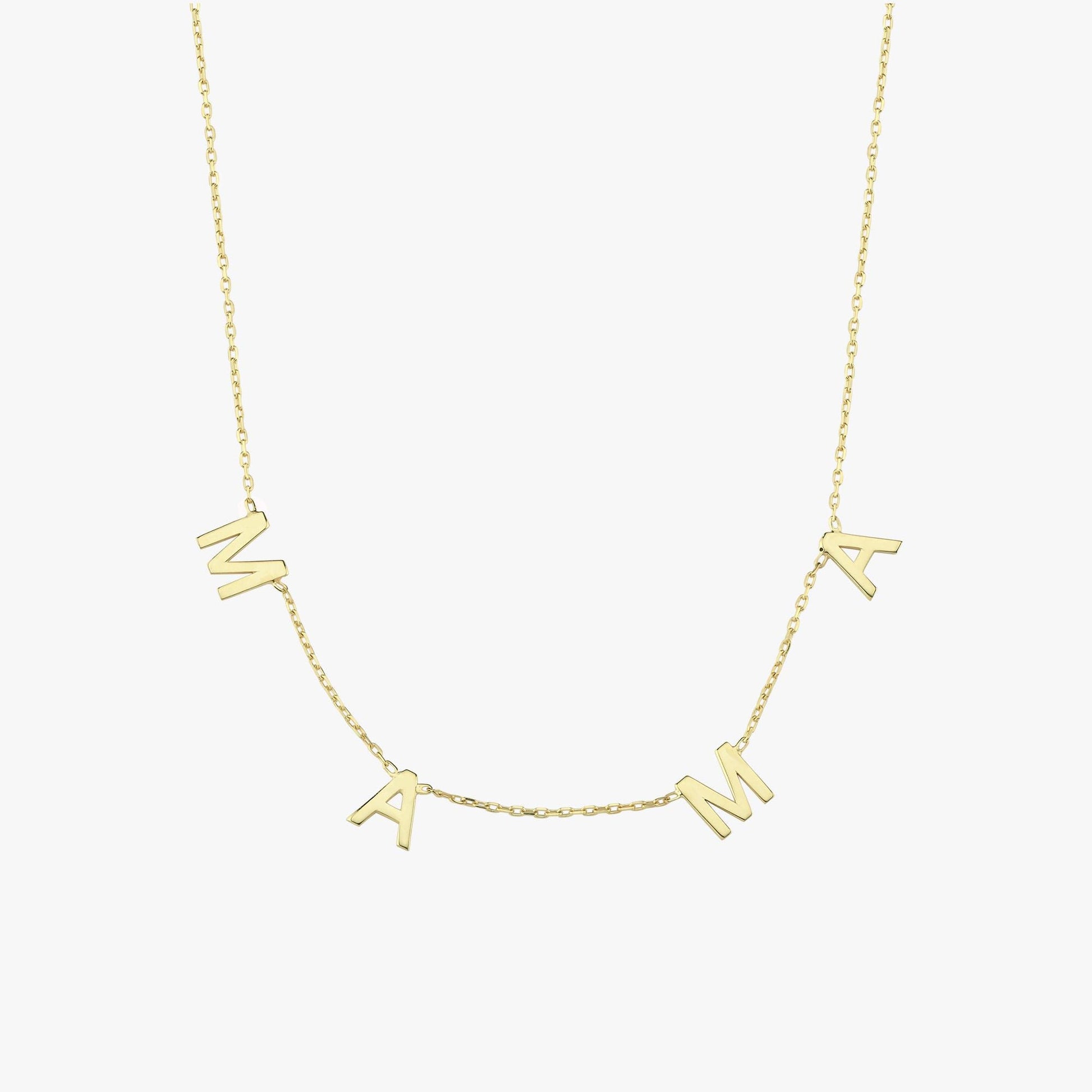 Detailed close-up of the "MAMA" letter charms on a 14K solid gold necklace, photographed against fair skin.