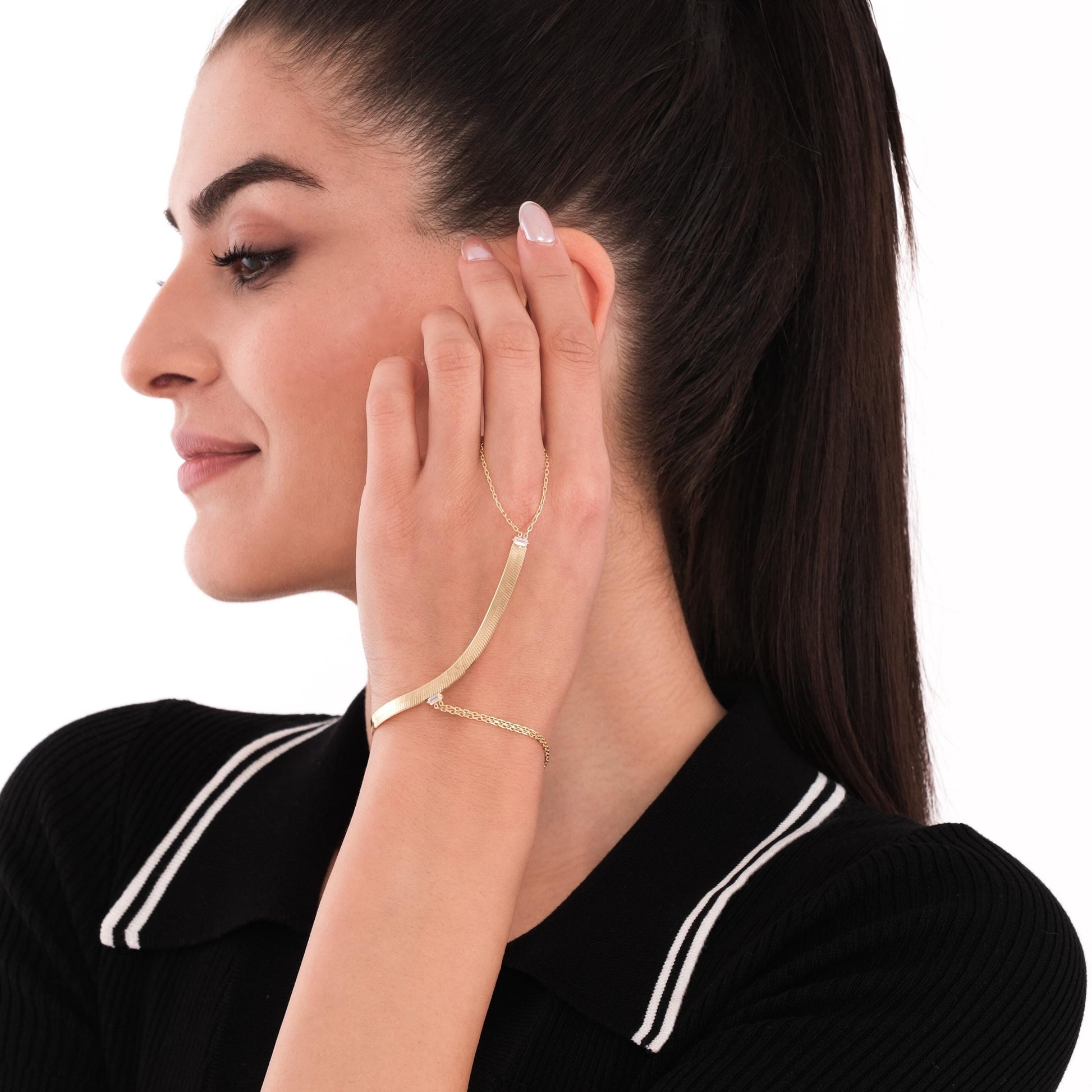 Profile view of a woman wearing an 18K gold vermeil slave bracelet, the curved gold bar resting smoothly along the back of her hand.