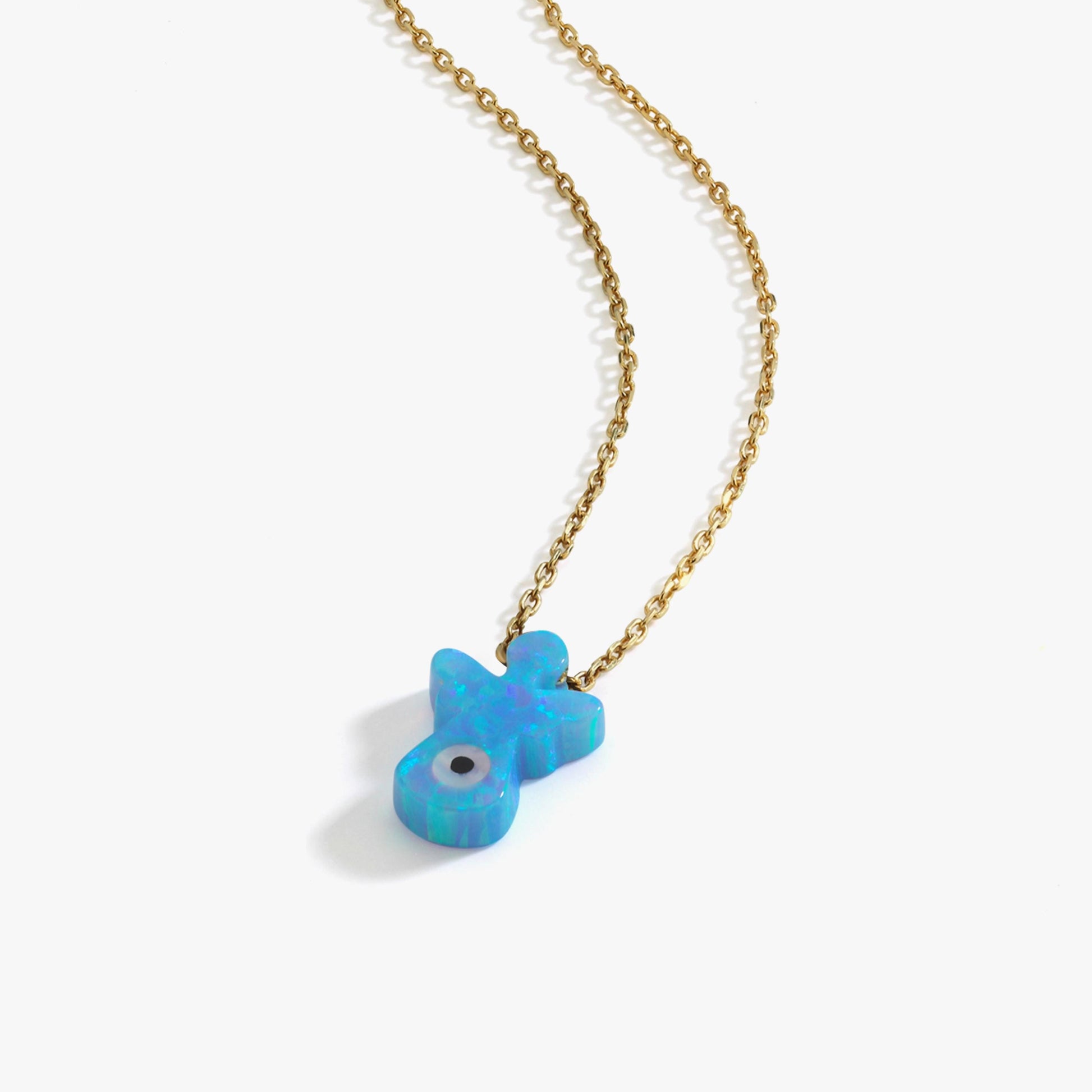 Flat lay of the 14K solid gold opal angel necklace featuring a shimmering blue opal angel pendant.