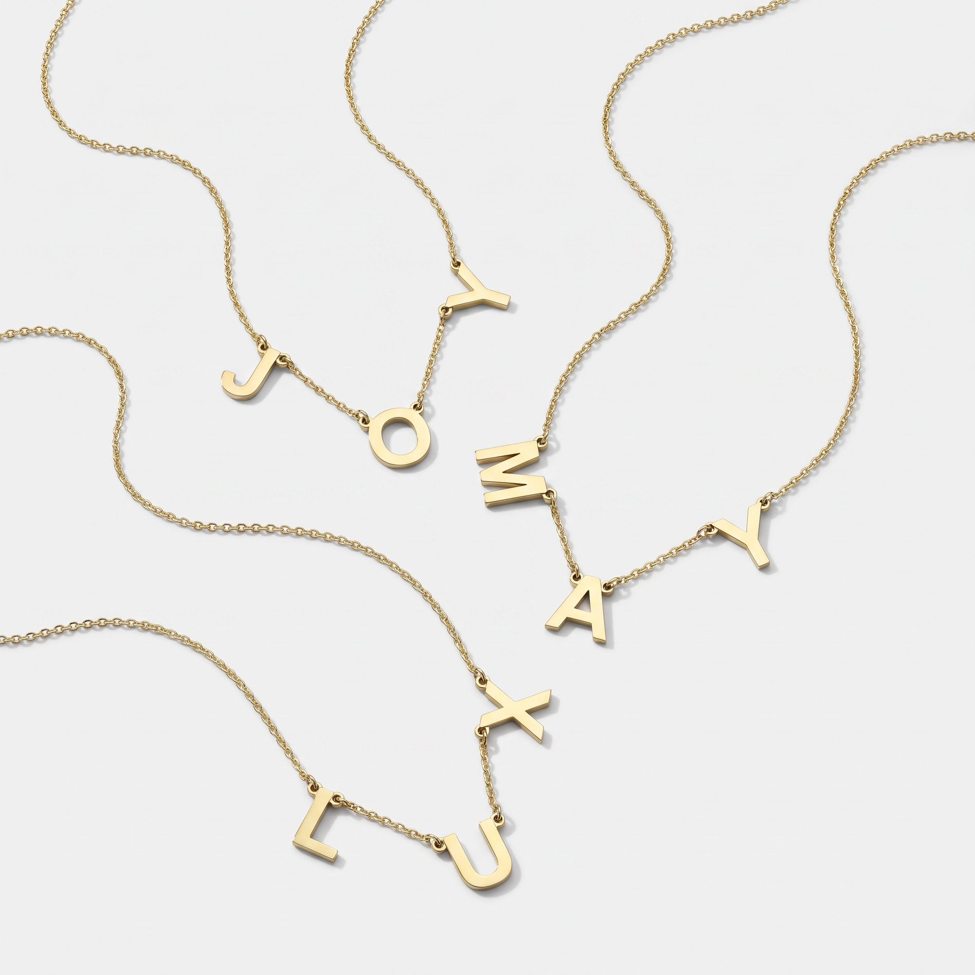Gold 3 initial necklaces with spaced letter charms on fine chains