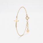 Gold sideways cross bracelet with a polished cross on a dainty cable chain, with spring ring clasp and extender