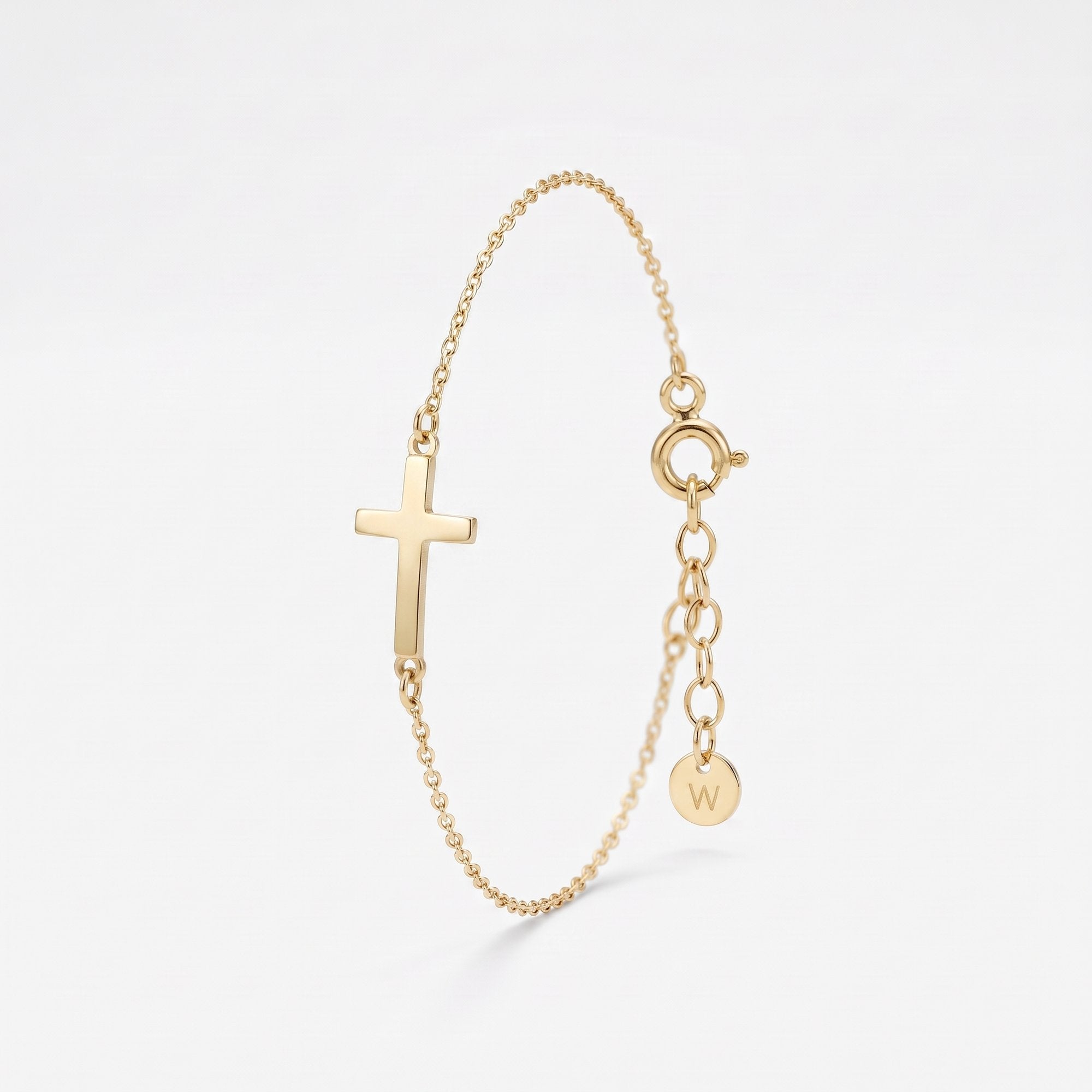 Gold sideways cross bracelet with a polished cross on a dainty cable chain, with spring ring clasp and extender