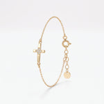 Tiny gold cross bracelet for women with five cubic zirconia stones at the center, a dainty chain bracelet with extender