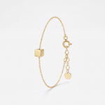 Gold initial bracelet with a polished cube charm for a custom engraved letter, on a dainty cable chain with extender