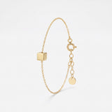 Gold initial bracelet with a polished cube charm for a custom engraved letter, on a dainty cable chain with extender