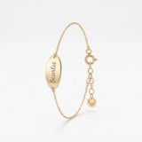 Custom engraved bracelet in 14K solid gold, an oval disc personalized with a name in script on a dainty chain