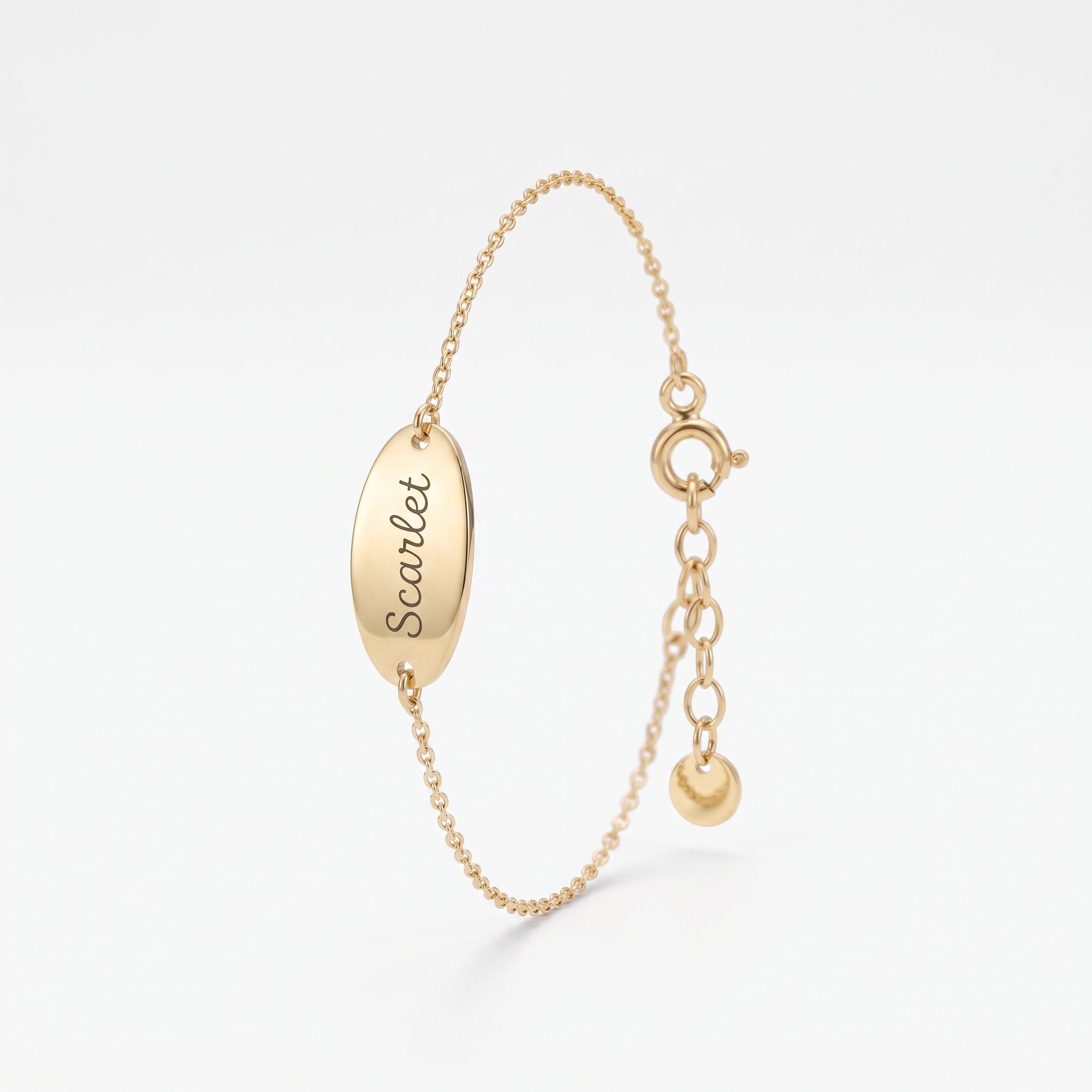 Custom engraved bracelet in 14K solid gold, an oval disc personalized with a name in script on a dainty chain
