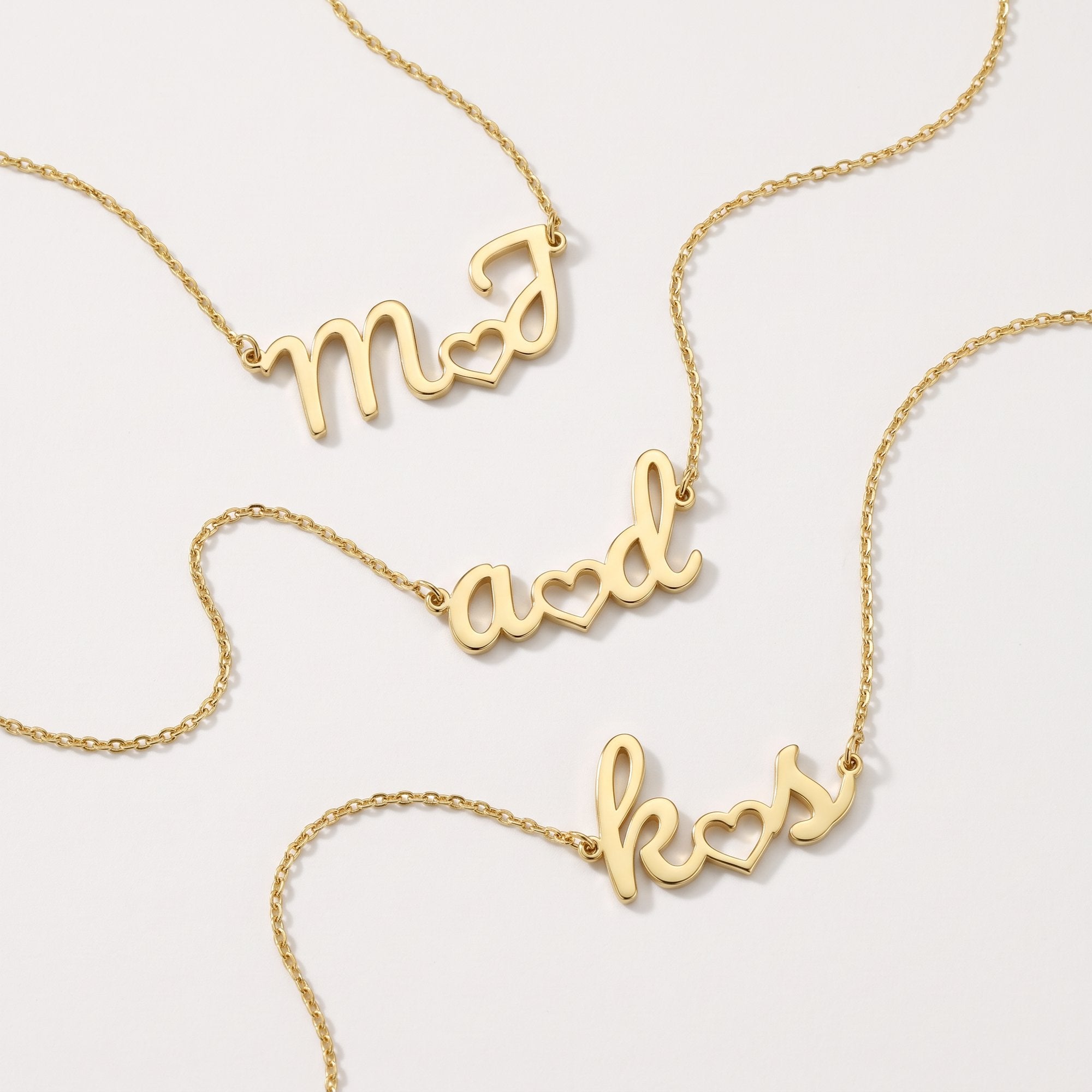 Gold custom initial necklaces with two initials joined by a heart