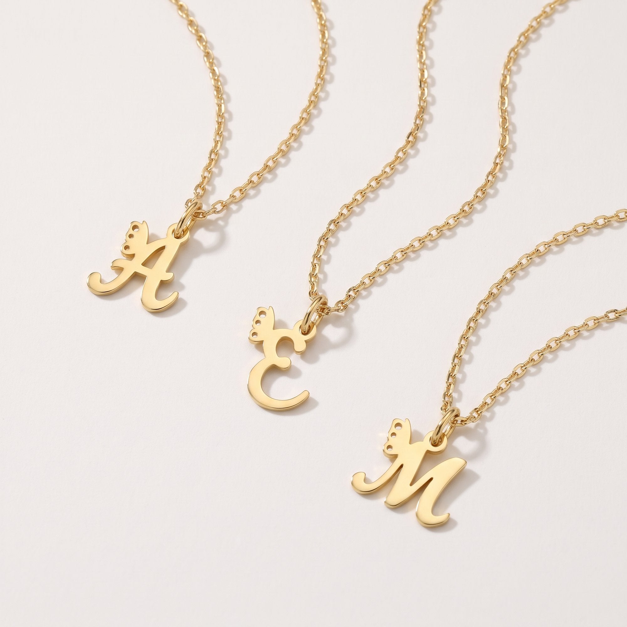 Gold custom letter necklaces with a butterfly on the initial pendant