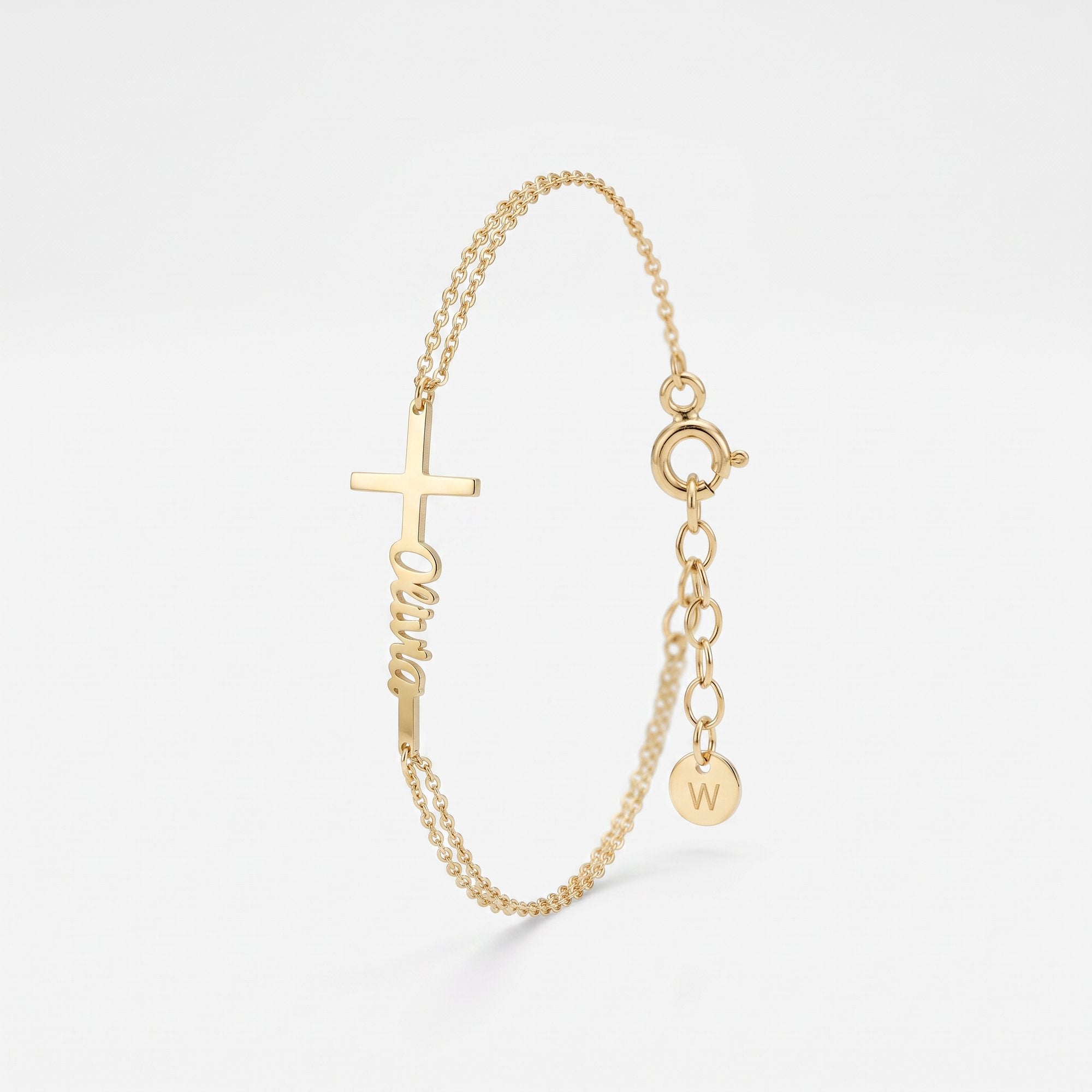 Gold name bracelet with a sideways cross and custom script name, a personalized baptism bracelet on a double cable chain