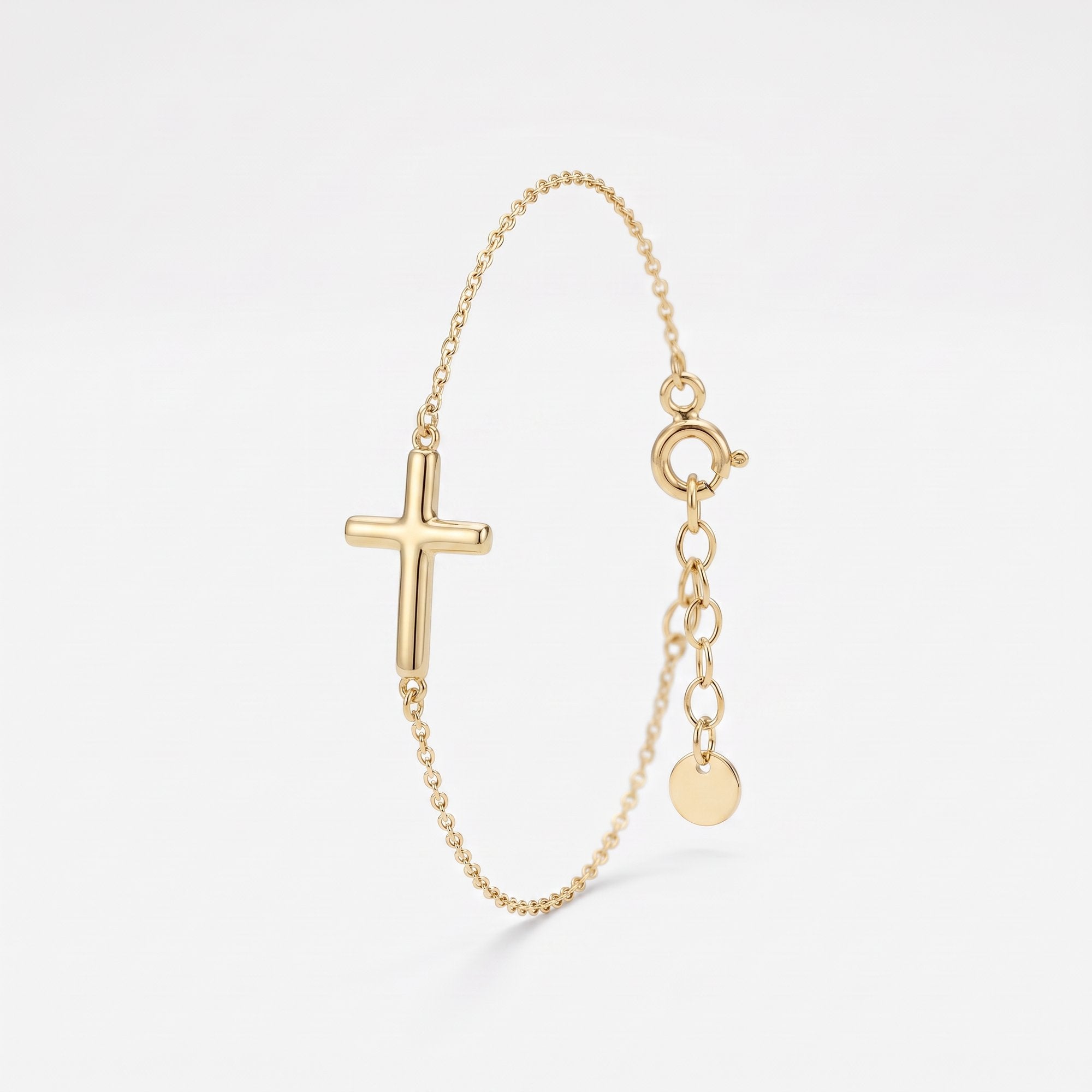 Dainty gold cross bracelet with a rounded sideways cross on a fine cable chain, with spring ring clasp and extender