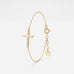 Dainty gold cross bracelet with a rounded sideways cross on a fine cable chain, with spring ring clasp and extender