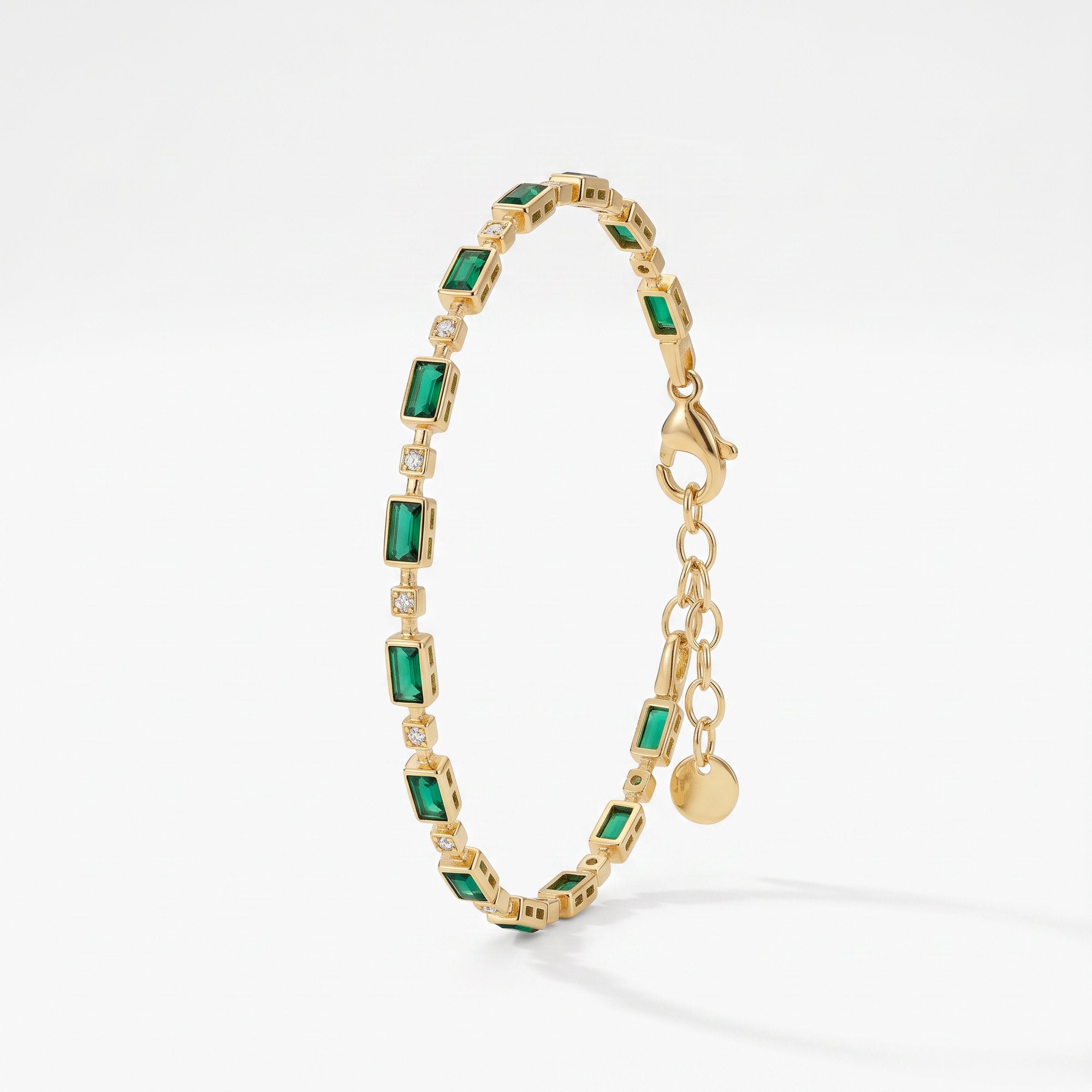 Emerald tennis bracelet in 18K gold vermeil with bezel-set emerald green baguette stones and small clear stones, with extender