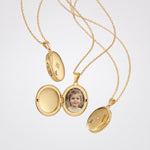 Gold oval photo locket necklaces, open with a child's photo and engraved initials
