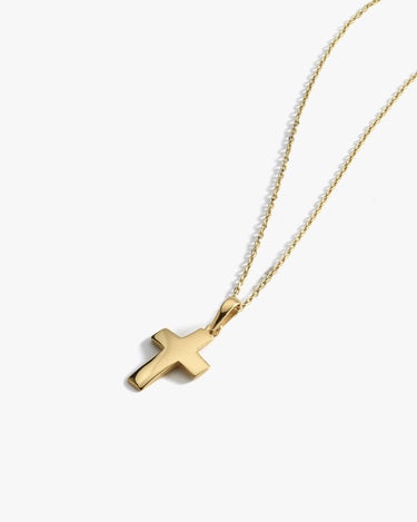 The Mionza Gold Cross Necklace in 14K Solid Gold showcases a simple, polished pendant on a delicate chain. The cross, with its clean lines and smooth finish, is centered against a white background. It features an adjustable length and is secured with a spring ring closure.