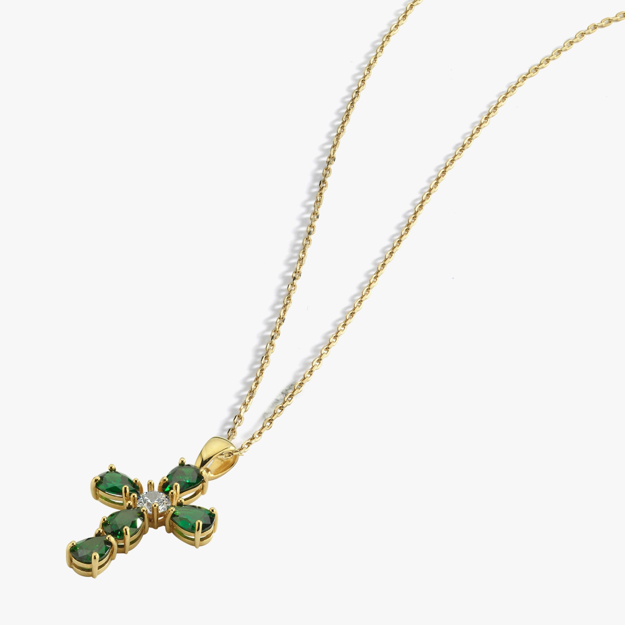 Gold chain with emerald cross pendant, white background, elegant jewelry design for fashion enthusiasts.