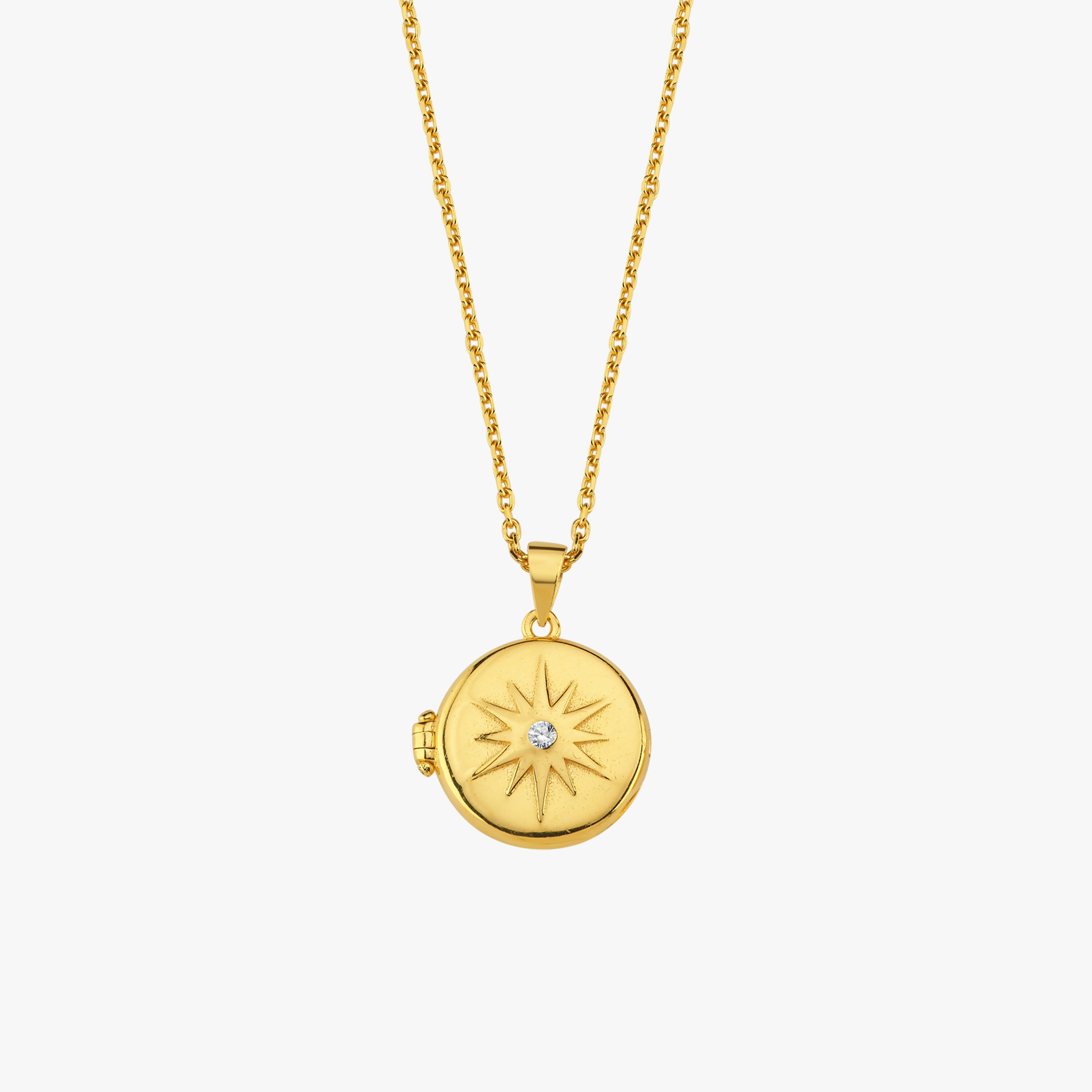 Gold pendant necklace with sunburst design and diamond center, elegance in minimalist jewelry style.