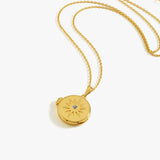 Elegant gold locket necklace with starburst design and gemstone, perfect for stylish jewelry lovers.