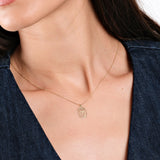 Woman wearing gold owl pendant necklace on delicate chain, paired with denim outfit. Perfect for stylish casual wear.