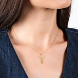 Gold cross necklace with personalized name pendant on woman wearing a dark denim shirt.
