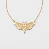 Gold moth necklace with leaf-engraved wings and moon phase body, a moth pendant on a fine cable chain