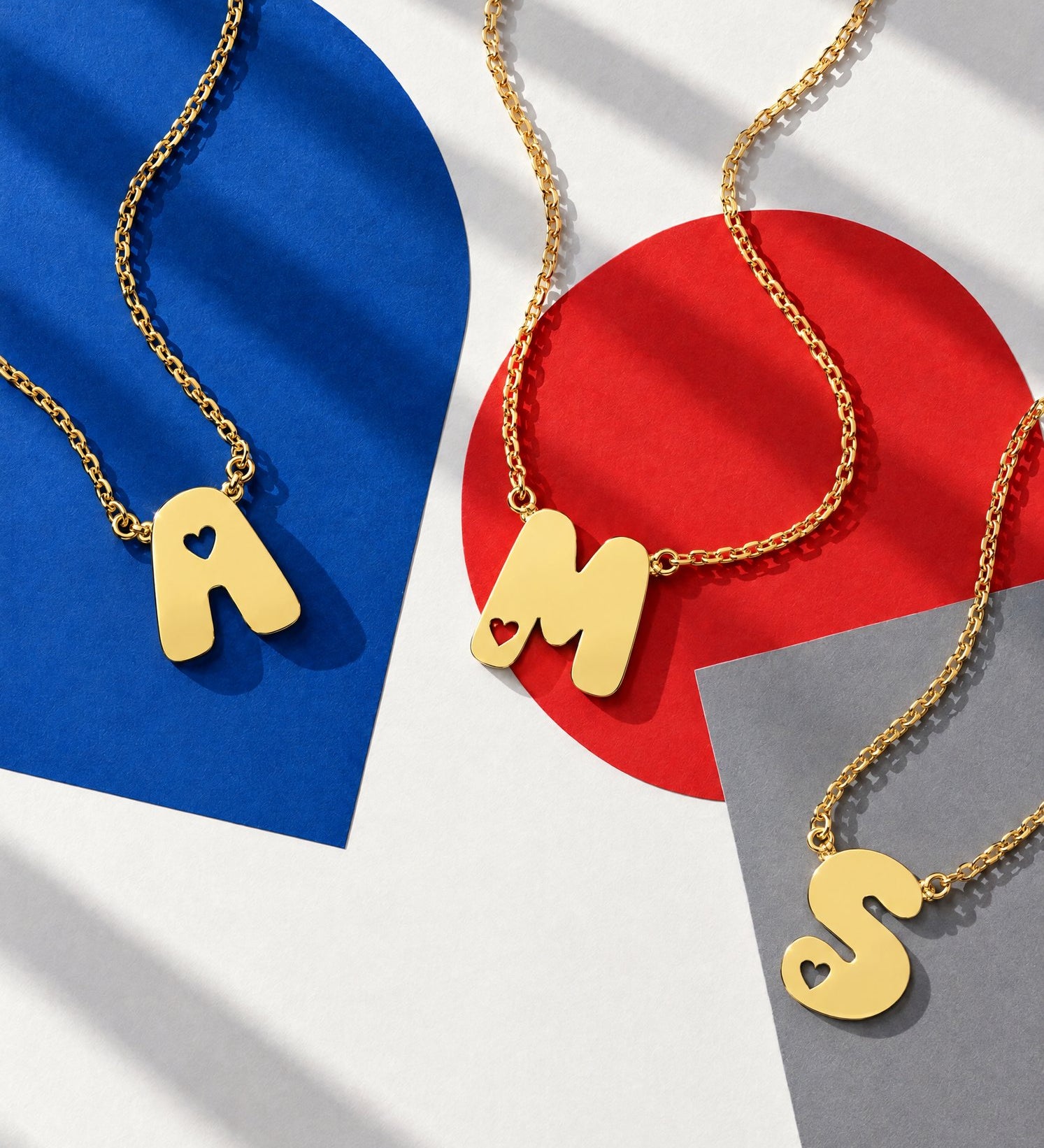 Gold bubble initial necklace with heart cut-out letter pendants A, M and S