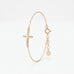 Dainty gold cross bracelet for women with a sideways cross set with cubic zirconia stones, on a fine chain with extender