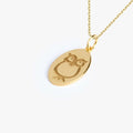 Detailed image of a 14K gold vermeil owl necklace showing the owl design engraved on an oval pendant.