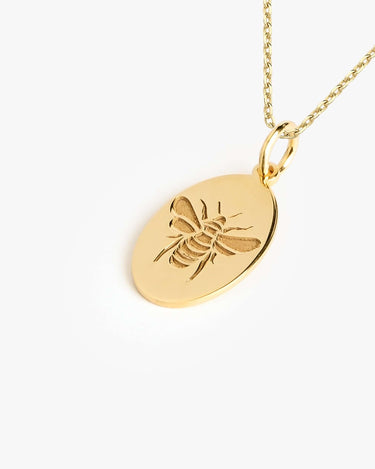 Detailed view of a 14K Gold Vermeil Bee Pendant Necklace with an embossed bee design on an oval pendant.