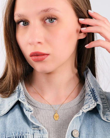 Young woman in grey shirt and denim jacket modeling a 14K Gold Vermeil Bee Pendant Necklace.