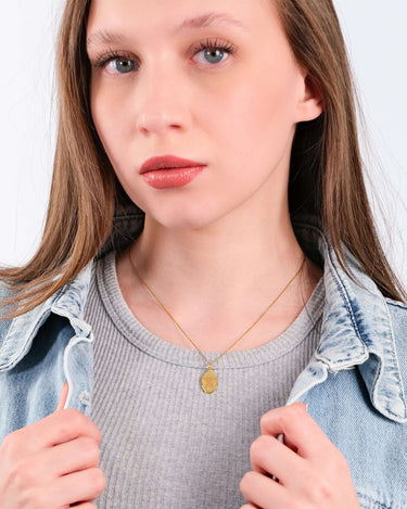 Close-up portrait of a young woman showcasing a 14K Gold Vermeil Bee Pendant Necklace under natural light.