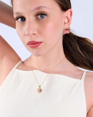 Young woman in a white top modeling a delicate 14K gold vermeil amethyst necklace, her gaze directed over her shoulder.