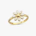 Gold ring featuring a daisy-like flower with white enamel petals, displayed against a white background.