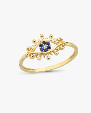 A gold evil eye ring with blue stones on a white background.