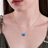 Close-up of a woman's neck showcasing a 14K solid gold necklace with a heart-shaped blue opal pendant.