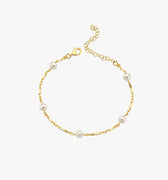 A minimalistic 18K gold vermeil bracelet with evenly spaced white pearls, elegantly laid out against a white background, displaying the simplicity and charm of the design.