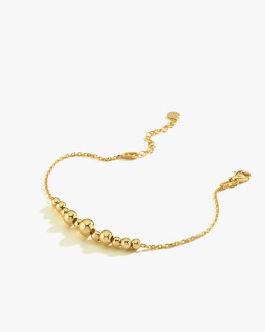 A standalone 18K Gold Vermeil beaded bracelet laid flat on a white background, showcasing its adjustable clasp and alternating bead sizes.